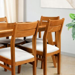 Wooden dining chairs with white cushions around table