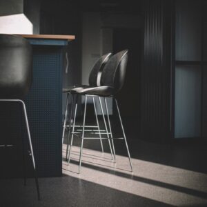 black leather padded seat beside black leather chair