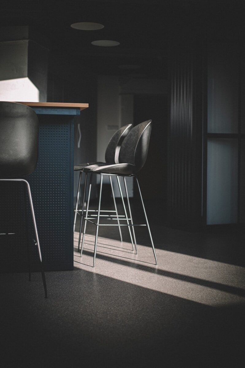 black leather padded seat beside black leather chair